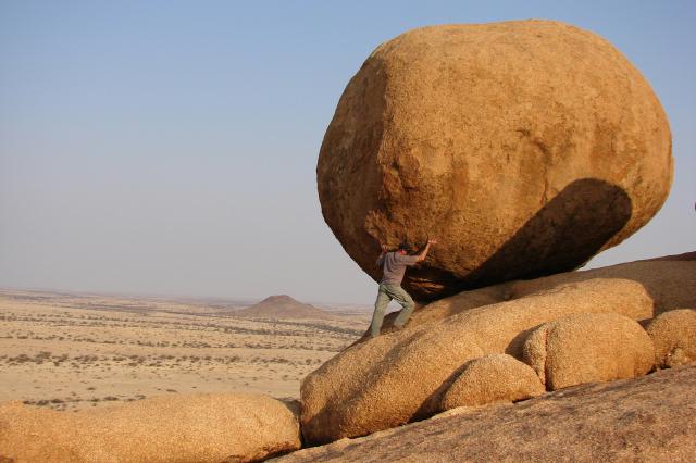 Man holding up a giant rock